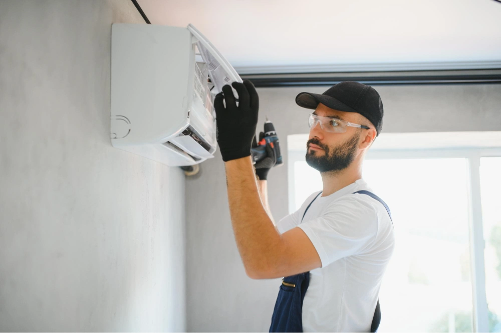 happy-male-technician-repairing-air-conditioner